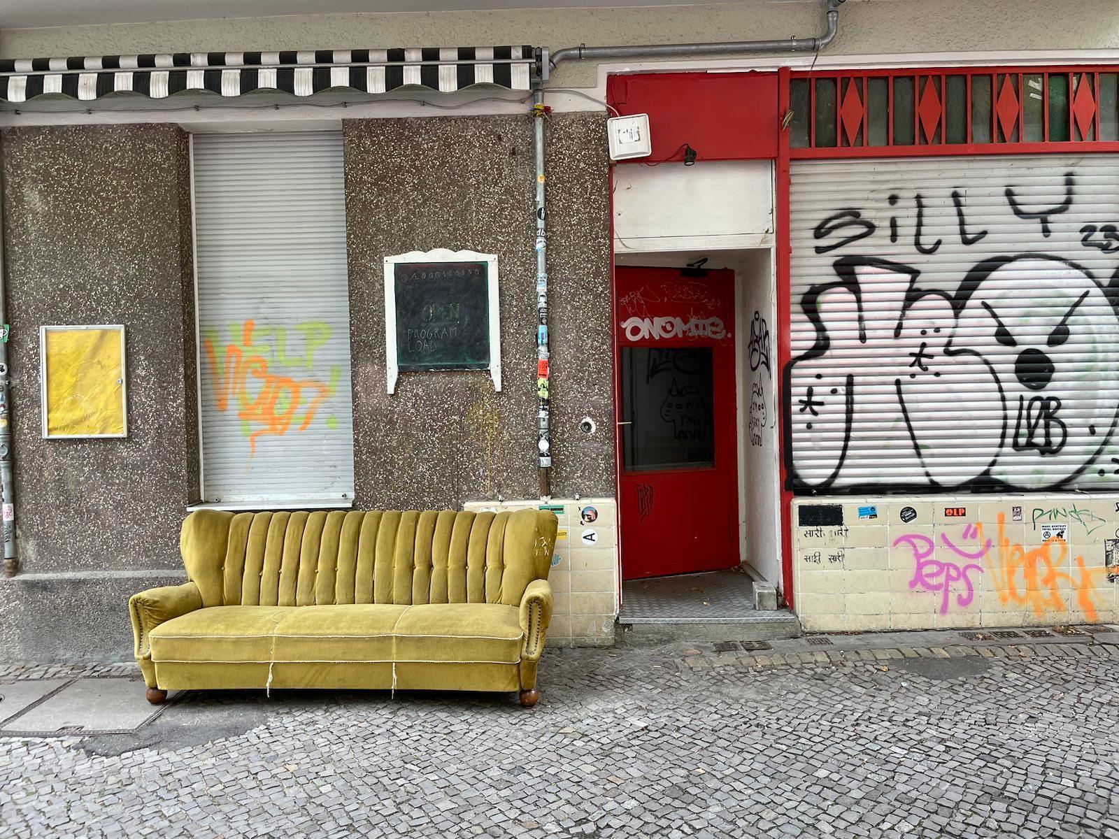 Front of the offline building, with graffiti and a yellow couch parked outside